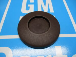 A black color disk shaped component placed on a blue surface