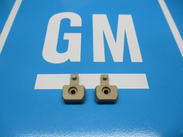 Two Small Brass Parts on a Blue Surface