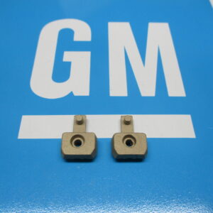 Two small parts of brass on a blue surface