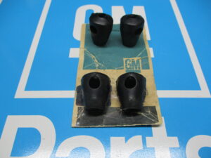 Four black color plastic components on a blue surface