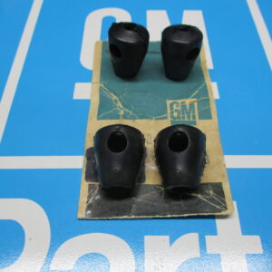 Four black color plastic components on a blue surface